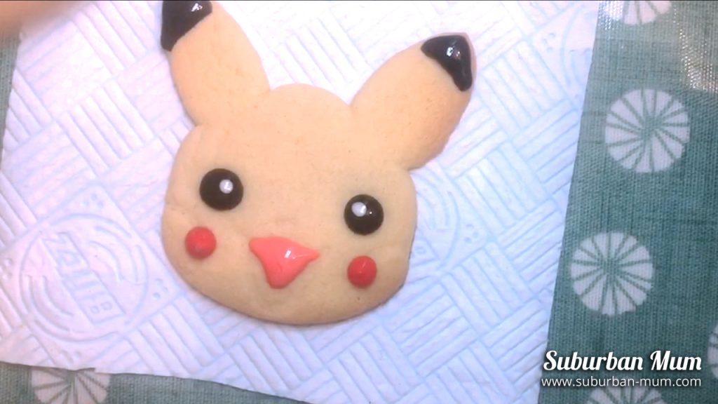 icing pikachus cheeks with red icing